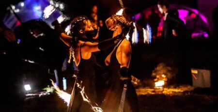 Fire dancers performing with flaming props at an outdoor event in Toronto