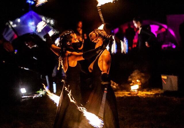 Fire dancers performing with flaming props at an outdoor event in Toronto