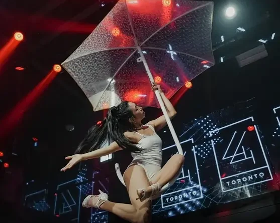 Aerial performer holding a transparent umbrella mid-air during a corporate event stage performance in Toronto