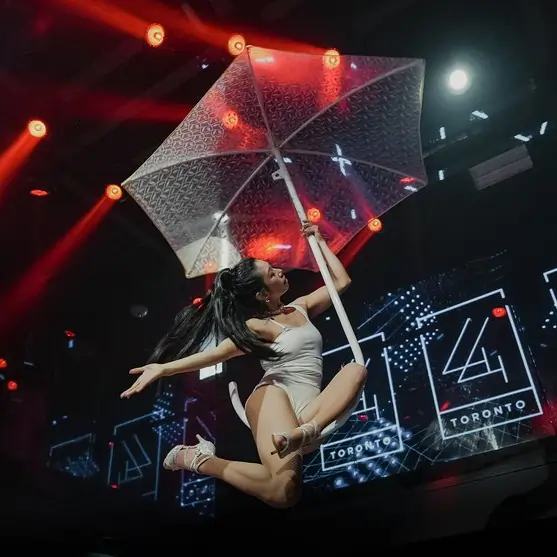 Aerial performer holding a transparent umbrella mid-air during a corporate event stage performance in Toronto