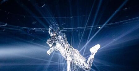 Mirror costume aerial performer suspended above a corporate event with dramatic lighting effects in Toronto.
